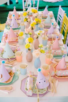 a table set for a birthday party with pastel colors