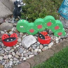 the very cute little ladybug garden is in the rocks by the grass and flowers