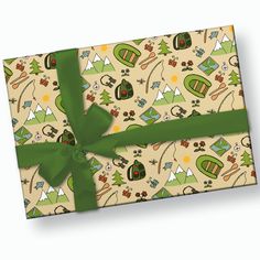 a gift box with a green bow on it's side and camping themed wrapping paper