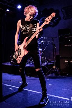 a young man playing an electric guitar on stage