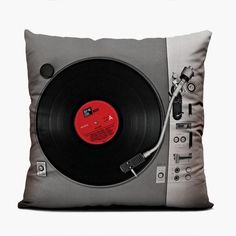 a pillow with a record player on it and a red disc in the center,