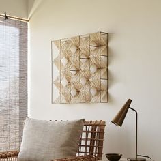 a wicker chair sitting next to a table with a lamp on top of it