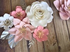 paper flowers are arranged on a wooden surface