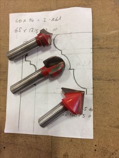 two red and silver tools on top of a piece of paper