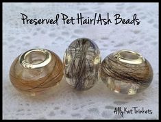 three glass bead caps with hair on them sitting on a white surface in front of the words preserved pet hair / ask beads