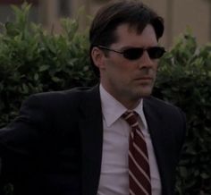 a man in a suit and tie with sunglasses on