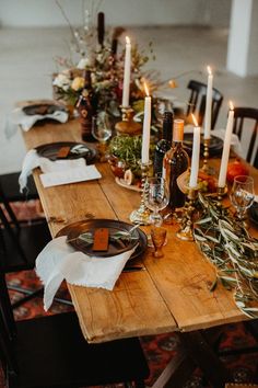 a wooden table topped with plates and candles