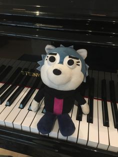 a stuffed animal sitting on top of a piano