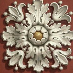 a white decorative object on a red wall