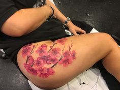 a woman's thigh with pink flowers painted on the side and behind her leg