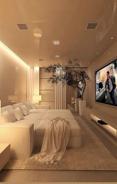 a living room filled with furniture and a flat screen tv mounted on the wall next to a plant