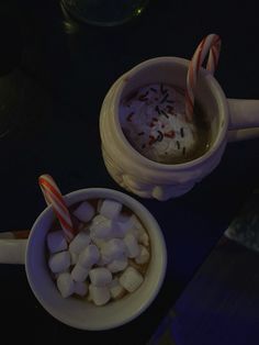 two cups filled with hot chocolate and marshmallows