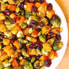 a white plate topped with brussel sprouts and sweet potatoes