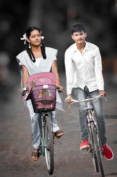 a man and woman are riding bicycles down the street with baskets on their back's wheels