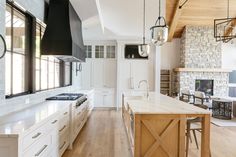 a large kitchen with white cabinets and wood floors