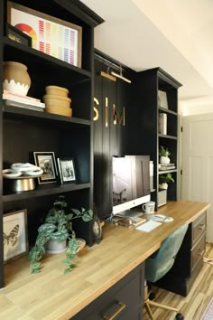 a home office with black bookcases and wooden desk top, along with bookshelves