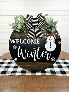 a welcome winter sign on top of a wooden table