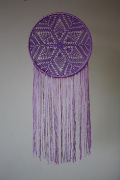 a purple dream catcher hanging on the wall