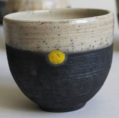 a black and white bowl with yellow dots on the inside is sitting on a table