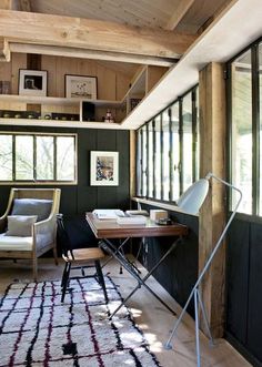 a living room filled with furniture next to a window covered in wood planks and windows