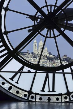 a large clock face with the city in the background