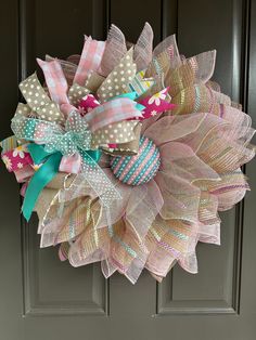 a wreath is hanging on the front door with polka dots and ribbons around it's center