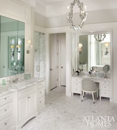 a large bathroom with two sinks, mirrors and a chandelier hanging from the ceiling