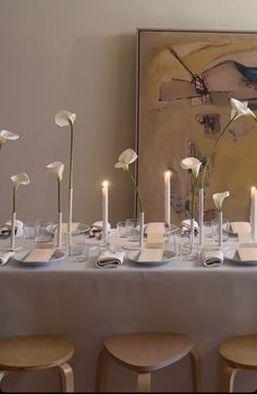 the table is set with white flowers and candles