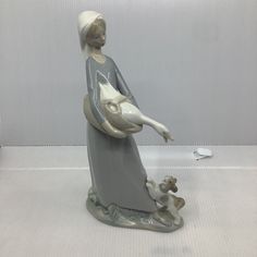 a figurine of a woman holding a dog