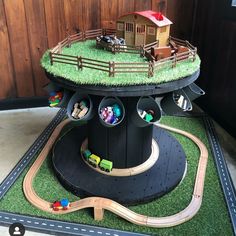 there is a train track in the shape of a tree with toy cars on it