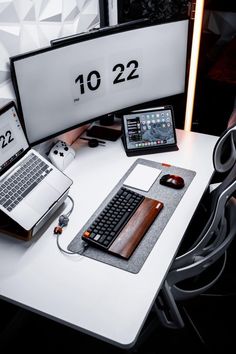 a desk with two laptops and a desktop computer on it, along with other electronic devices