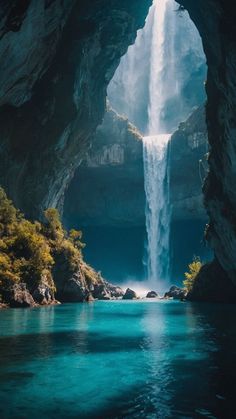 a waterfall is seen from the inside of a cave