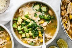 two bowls of chicken tortilla soup with avocado and cilantro