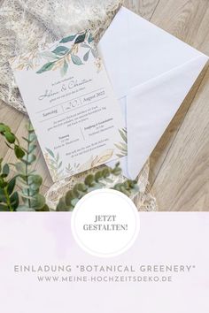 the wedding stationery is laid out on top of an envelope and some greenery