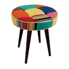 a colorful patchwork stool with wooden legs