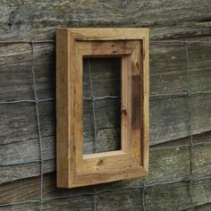 a wooden frame hanging on the side of a fence