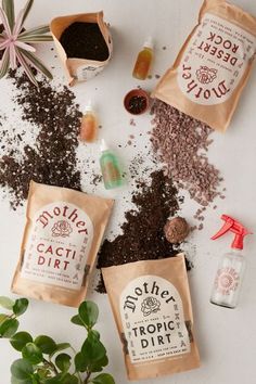 three bags of dirt sitting on top of a table next to plants and other items