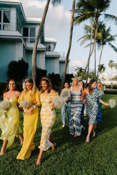 the bridesmaids are walking down the aisle with their bouquets in hand and one is wearing a yellow dress