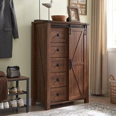 a wooden cabinet with doors and drawers next to a rug in front of a window