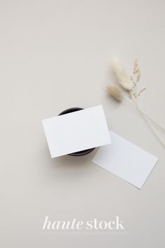 an empty business card next to some dried plants