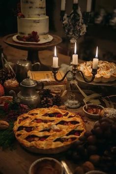 a table topped with lots of pies and candles