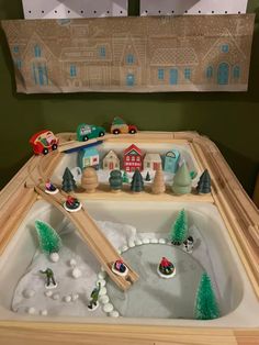 a toy train set sitting on top of a wooden table next to a christmas tree