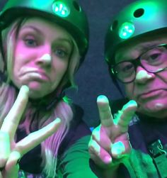 two people wearing helmets making the peace sign