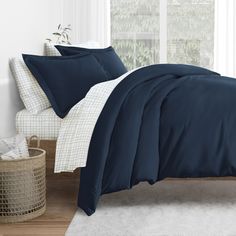 a bed with blue sheets and white pillows