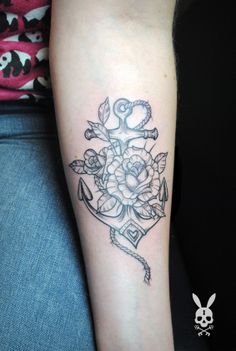 a black and white photo of a flower tattoo on the left arm, with an anchor in the middle