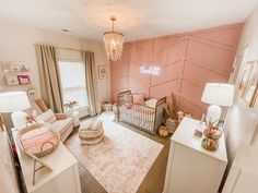 a baby's room with pink walls and furniture in the corner, including a crib