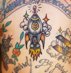 the back of a man's chest with tattoos on it and an image of a rocket ship