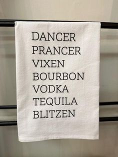 a tea towel hanging on the side of a metal rack with words written across it