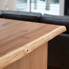 a wooden counter top sitting in front of a black couch