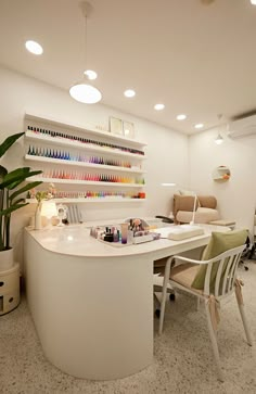 an office with white desks and chairs in front of a wall full of nail polish bottles